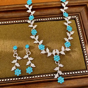 Elegant silver necklace and earring set with blue floral leaf rhinestone design