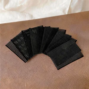 Dettaglio della texture degli adesivi magici neri per capelli per fissare le ciocche