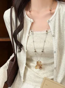 Gros plan d'un collier pendentif ours mignon avec des perles en verre marron sur modèle