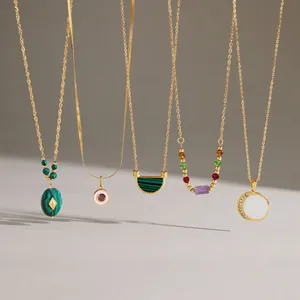 Detailed view of assorted gold titanium steel necklaces with various gemstone pendants