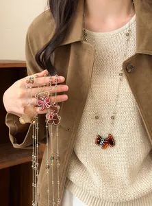 Vue détaillée de colliers pendentifs ours vintage avec d'élégantes perles de verre
