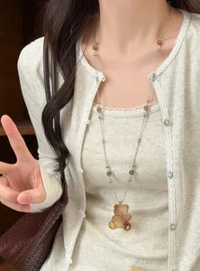 Détail d'un collier pendentif ours rétro avec des perles de verre marron sur un mannequin