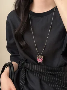 Gros plan d'un collier ours de style vintage avec perles de verre sombres sur un mannequin