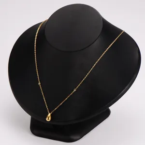 Elegante goudkleurige ketting met druppelhanger op een zwarte display voor sieraden.