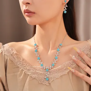 Nahaufnahme eines eleganten silbernen Halsketten-Sets mit blauen Strasssteinen und Blumen