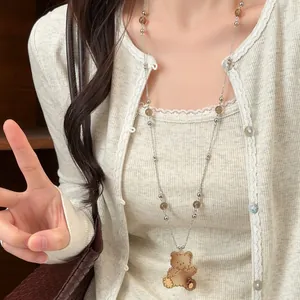 Collana lunga in stile vintage con ciondolo a forma di orsetto e perline di vetro.
