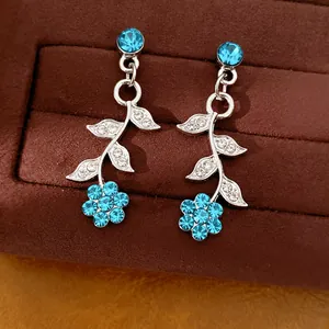 Detailansicht eleganter Blatt-Ohrhänger mit hellblauen Blumenkristallen
