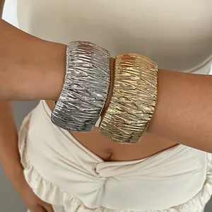 Detail of gold and silver metallic bangles with a unique crinkled texture on arm