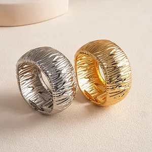 Close-up of gold and silver metallic bangles featuring unique crinkled texture detail.