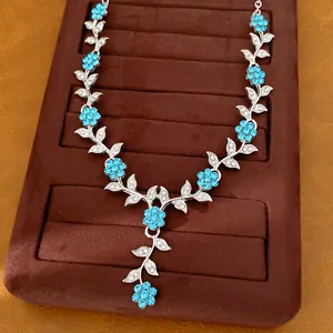 Detailansicht einer silberfarbenen Blumenkette mit blauen Strasssteinen und Blättern