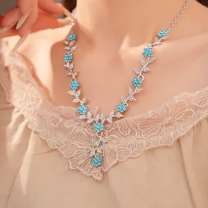 Elegante Detailaufnahme einer Halskette mit blauen Strassblumen und Blättern an einem Model