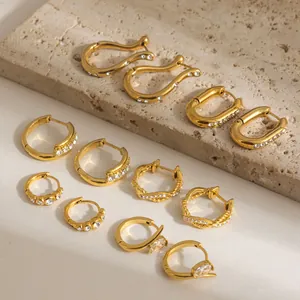 Detalle de alta calidad de pendientes de aro de acero inoxidable dorado con circonitas