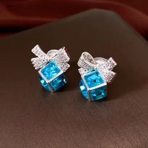 Détail de boucles d'oreilles clips en cristal bleu avec un élégant design de nœud scintillant