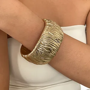 Detailed close-up showing the unique wrinkled texture of a chunky gold cuff bracelet