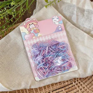 Detail shot of colorful disposable elastic hair bands in cute pink cartoon packaging