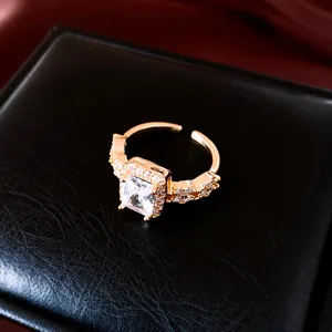 Gros plan d'une bague ouverte carrée en zircone plaquée or 18k sur boîte noire