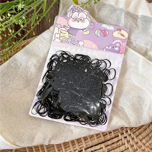 Detailed view of black disposable rubber hair elastics in cute purple cartoon packaging box
