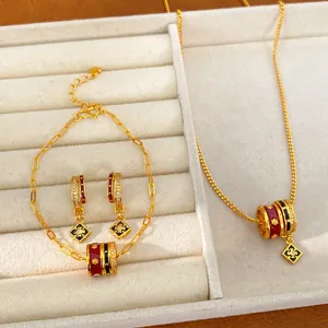 Exquisite 24K gold plated jewelry set with red and black enamel flower charms in a display tray