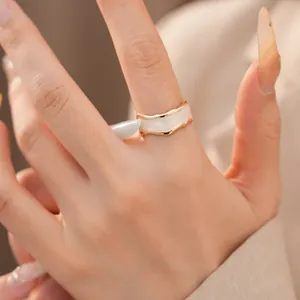 Nahaufnahme eines minimalistischen unregelmäßigen Goldrings mit perlweißer Emailleeinlage