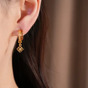 Detail of 24K gold plated hoop earring with zircon floral pendant and black enamel finish