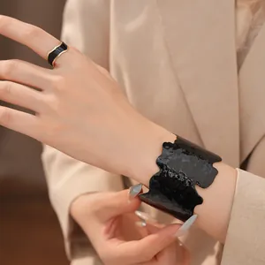 Detailansicht eines schwarzen Emaille-Armreifs und passenden Rings im Set für Damen