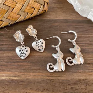 Vintage silver cat stud earrings with cartoon heart pendants and sparkly rhinestone accents
