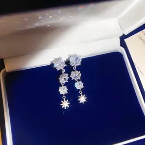 Nahaufnahme von funkelnden Zirkonia-Stern-Quastenohrringen in einer blauen Box