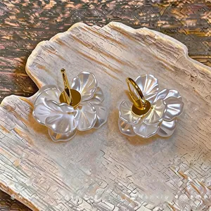 Détail de boucles d'oreilles pétales blanc givré avec anneaux plaqués or 14 carats