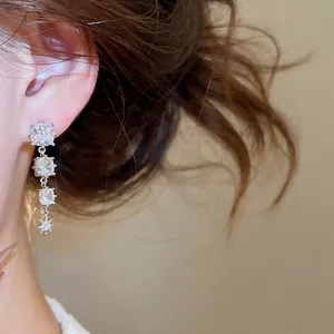 Nahaufnahme eleganter Silber-Quastenohrringe mit funkelnden Sternen und Zirkonia