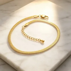 Detailed view of a 3mm 18K gold plated stainless steel blade chain on white marble surface