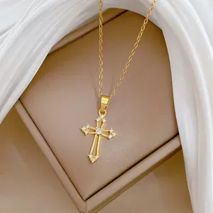 Vue détaillée d'un collier à croix dorée évidée avec des zircons cubiques étincelants