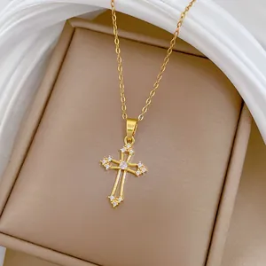 Vue détaillée d'un pendentif croix en acier titane doré orné de strass scintillants