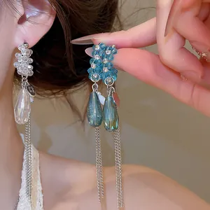 Gros plan de boucles d'oreilles à pampilles en cristal bleu avec élégants pendentifs goutte.