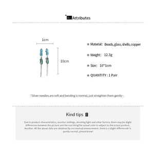 Détail macro de boucles d'oreilles à pompons en cristal avec dimensions et matériaux