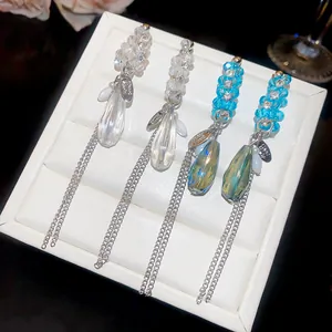 Détail en gros plan de boucles d'oreilles à pampilles en cristal sur un plateau blanc