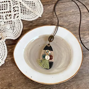 Collana etnica fatta a mano a forma di goccia con bottoni in legno e nappe verdi