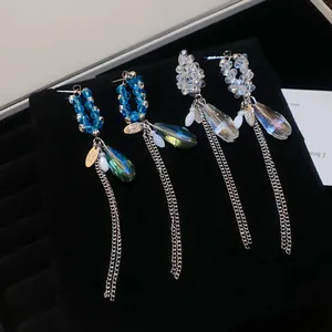 Gros plan de boucles d'oreilles en cristal étincelant avec pendentifs sur velours noir