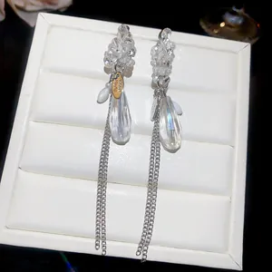 Gros plan de boucles d'oreilles à pampilles en cristal avec chaînes argentées