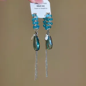 Vue détaillée de boucles d'oreilles pampilles en cristal bleu avec strass et pendentif goutte