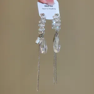 Gros plan de boucles d'oreilles en cristal étincelant avec de longues chaînes d'argent