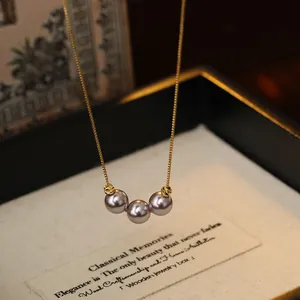 Close-up detail of 18k gold plated necklace with three elegant purple pearls
