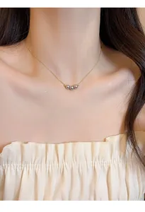 Close-up of 18k gold plated clavicle chain necklace with three elegant purple pearls