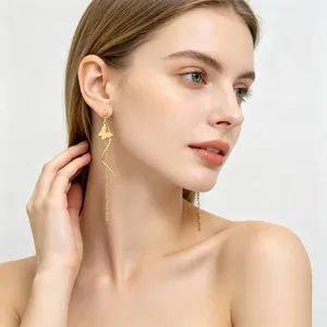 Vue détaillée de boucles d'oreilles papillon dorées en acier inoxydable