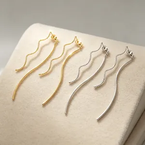 Gros plan détaillé de boucles d'oreilles ondulées or et argent sur support velours