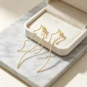 Vue détaillée de boucles d'oreilles dorées en acier inoxydable sur une boîte à bijoux