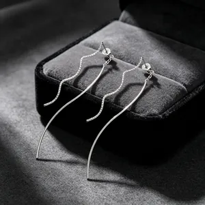 Gros plan élégant de boucles d'oreilles minimalistes en acier inoxydable ondulé