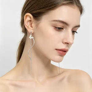 Vue détaillée d'une boucle d'oreille papillon en acier inoxydable portée par un mannequin
