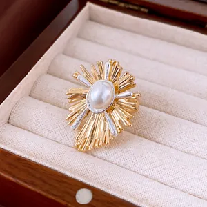 Exquisite Nahaufnahme eines Retro-Perlenrings mit goldenen, sonnenstrahlförmigen Metallstrahlen