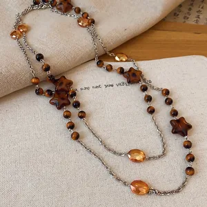 Detail shot of a vintage beaded necklace with amber crystal and star-shaped accents.