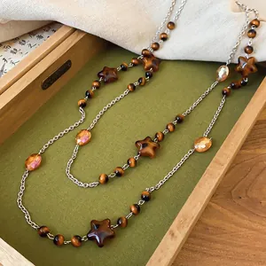 Detailed view of a retro beaded sweater necklace with wooden stars and amber beads